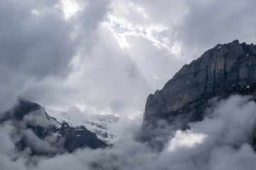 Wall Mural - Hight Alps mountains and white clody sky with sunlight