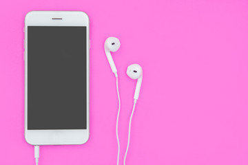 Smartphone with Earphones on pink background with copy space and clipping path. Flat lay. Top view.