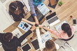 © InfiniteFlow - Businessmen and businesswomen joining hands in group meeting at multicultural office room showing teamwork, support and unity in business. Diversity workplace and corporate people working concept.