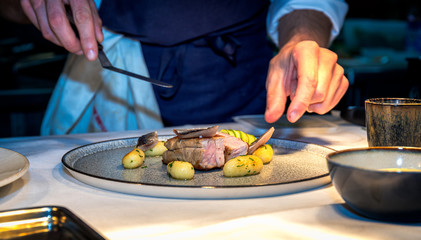 Chef preparing luxury meal made of meat and gnocchies