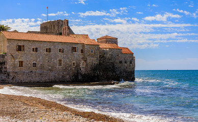 View of Budva Old Town Citadel and the Adriatic Sea from Richard s Head beach in Montenegro, Balkans on a sunny day