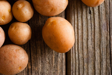 Wall Mural - petite potatoes on rustic wood table background