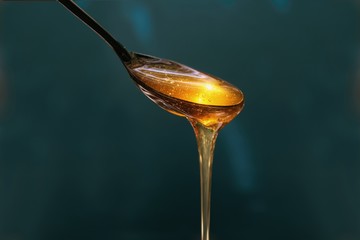 delicious honey pours out of the spoon close up