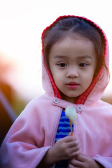 Adorable toddler girl having fun on winter day. Children play outdoors. Winter fashion for kids.