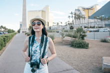 Background With Egyptian Statues In Row At Hotel And Casino In Las Vegas Nevada. Young Girl Travel Photographer Carry Camera Walking On City Street Outdoor Relax. Smiling Female Tourist Enjoy Summer