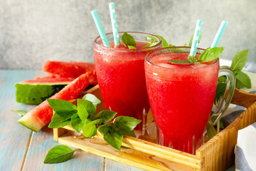 Cold Watermelon Smoothie. Summer Watermelon drink in glasses and slices of watermelon on rustic wooden table.