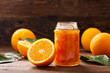 glass jar of orange  jam with fresh fruits