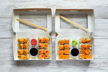 Two sushi set in a box on a wooden table. Street food