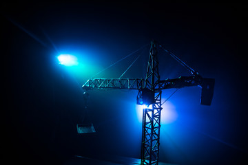 Abstract Industrial background with construction crane silhouette over amazing sunset sky. Tower crane against the evening sky. Industrial skyline