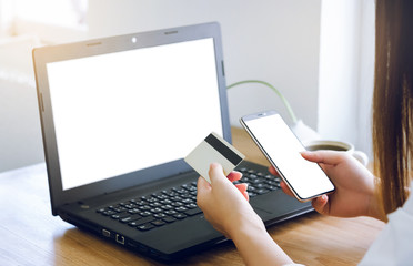 Wall Mural - Closeup young asian woman working with laptop and using credit card to payment and shopping on line