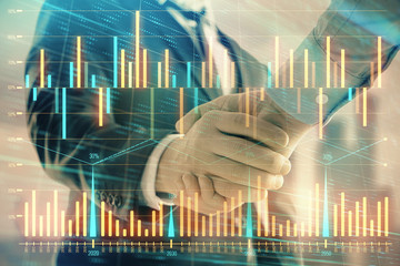 Double exposure of financial graph on cityscape background with two businessman handshake. Concept of stock market deal