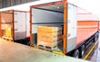Package Boxes Loading into Cargo Container. Trailer Truck Parked Loading at Dock Warehouse. Delivery Service. Shipping Warehouse Logistics. Cargo Shipment Boxes. Freight Truck Transportation.