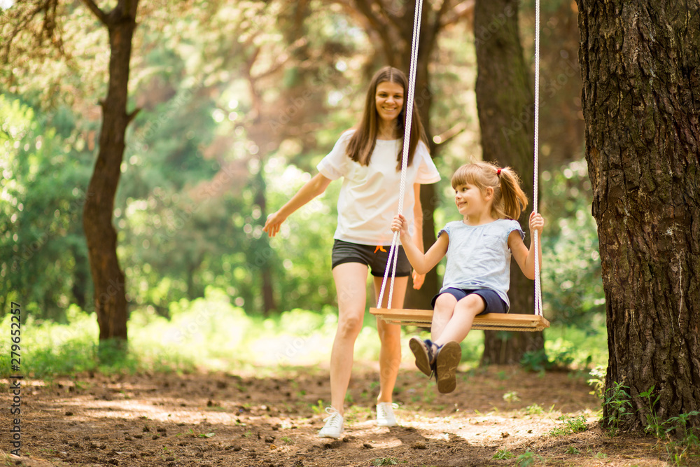 happy mother pushing laughing daughter on swing in a park Stock Photo ...