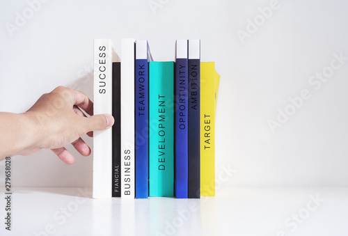 Cuadros en Lienzo Hand picking success book from bookshelf