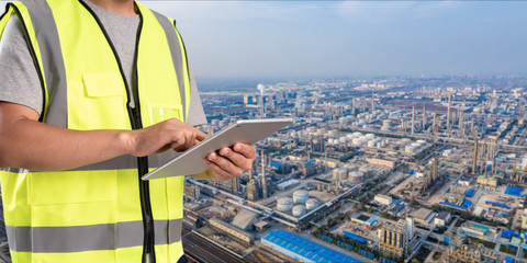 Wall Mural - worker working on pad with oil and gas refinery background,Smart factory concept.