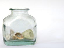 Old Rustic Glass Jar With Shells And Beach Pebble Inside On White Backlground