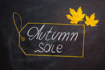 yellow leaves and inscription autumn on a blackboard