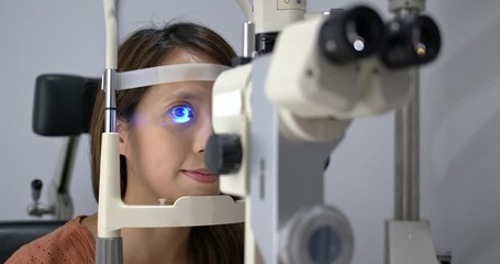 Poster - Woman check on eye in clinic