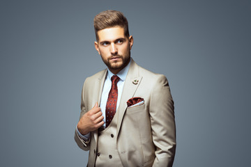 Wall Mural - Stylish young man in suit and tie. Business style. Fashionable image. Office worker. Sexy man standing and looking at the camera