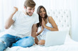 © opolja - Young couple with laptop in the bed in room.