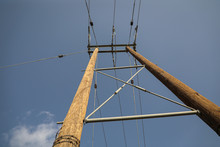 Wooden Power Poles With A Blue Sky Background