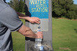 Man filling water bottle at water refill station