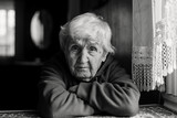 Fototapeta  - Portrait of a lonely sad old woman. Black and white photo.