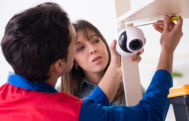 Client getting securty camera installed at home by contractor