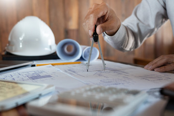 Wall Mural - Confident engineer team working with Blue Print with architect equipment discussing and Planning work flow construction project. with partner at the table in office work site