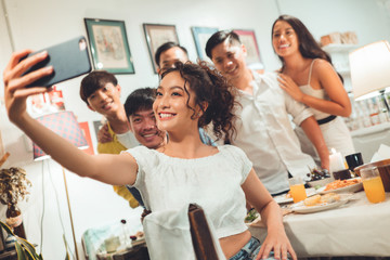 Wall Mural - Group friends asian are taking selfies while eating dinner.