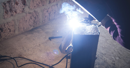 Wall Mural - Welder performs welding work on metal in protective mask.