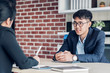 © weedezign - young asian businessman and businesswoman talking about business agreement at meeting table in modern office.business partnership concept.satisfied the deal with client negotiation