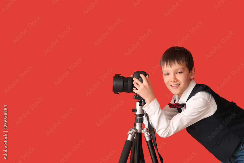 Cute little photographer on color background