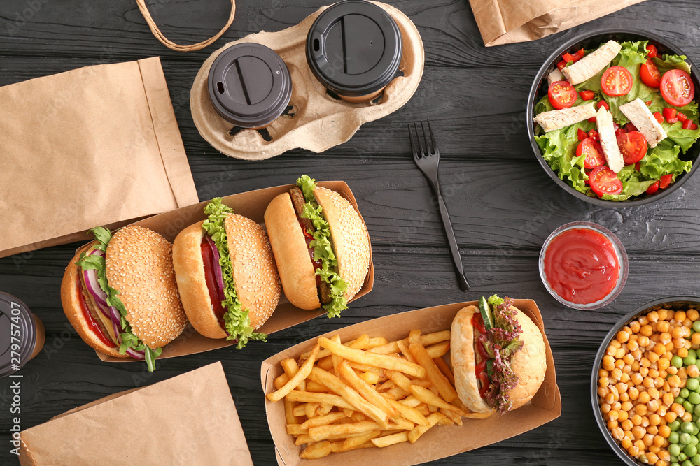 Different tasty food from delivery service on wooden background - obrazy, fototapety, plakaty 