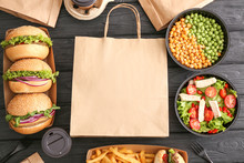 Different Tasty Food From Delivery Service On Wooden Background