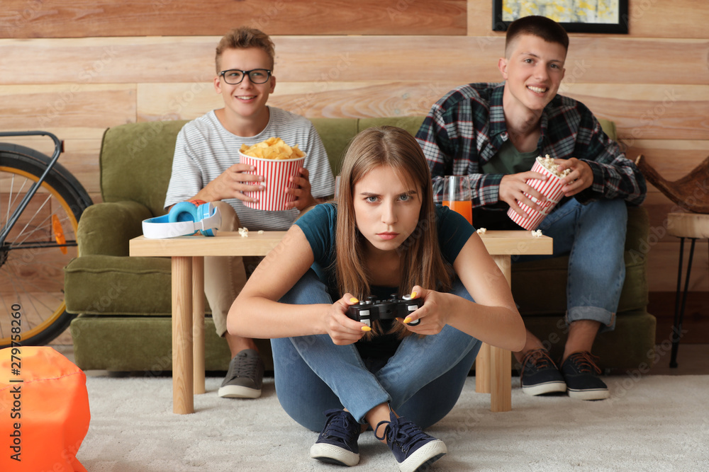 Teenagers playing video game at home