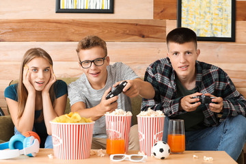 Wall Mural - Teenagers playing video game at home
