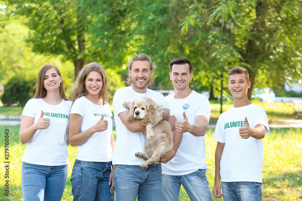 Volunteers with cute dog outdoors