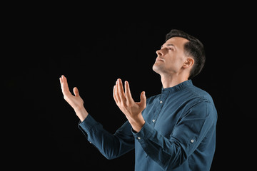 Poster - Religious man praying to God on dark background