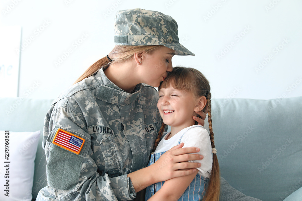 Happy female soldier with her daughter at home