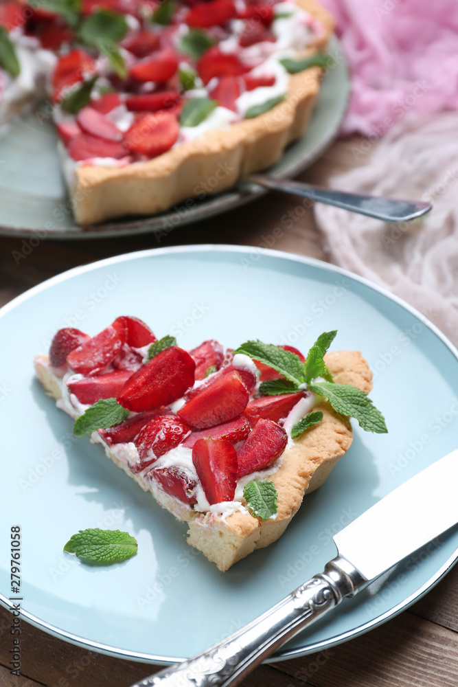 Plate with piece of tasty strawberry cake on table