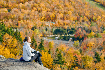 Wall Mural - Woman hiking at Artist's Bluff in autumn. Fall colours in Franconia Notch State Park. White Mountain National Forest, New Hampshire, USA