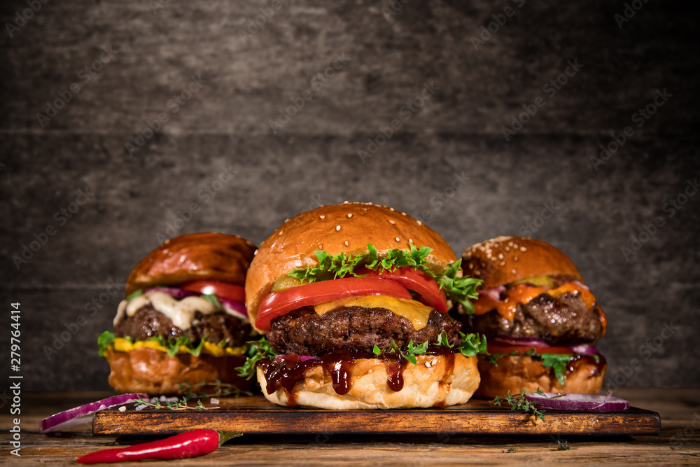 Obraz Close-up of home made tasty burgers on wooden table. fototapeta, plakat