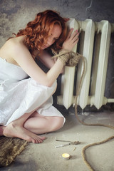 Young girl tied up on the floor. The abducted girl. The victim of violence sits on the floor with tied hands. Domestic violence.