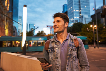 Poster - Attractive young man walking at the city streets in the evening