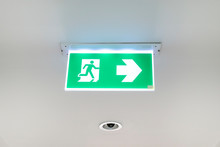 Fire Exit Sign. Emergency Fire Exit Door Exit Door On Ceiling. Green Emergency Exit Sign Showing The Way.