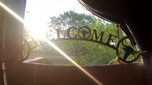 Welcome Sign Sitting In A Screen Door On The Window Frame On A Sunny Day. ( 4k Footage )
