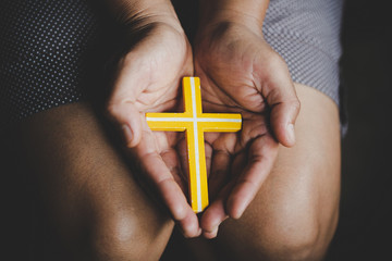 Spirituality and religion,Women in religious concepts Hands praying to God while holding the cross symbol. Nun caught the cross in his hand.