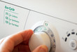 © Steve - Close up of hand selecting green eco cycle programme on washing machine.