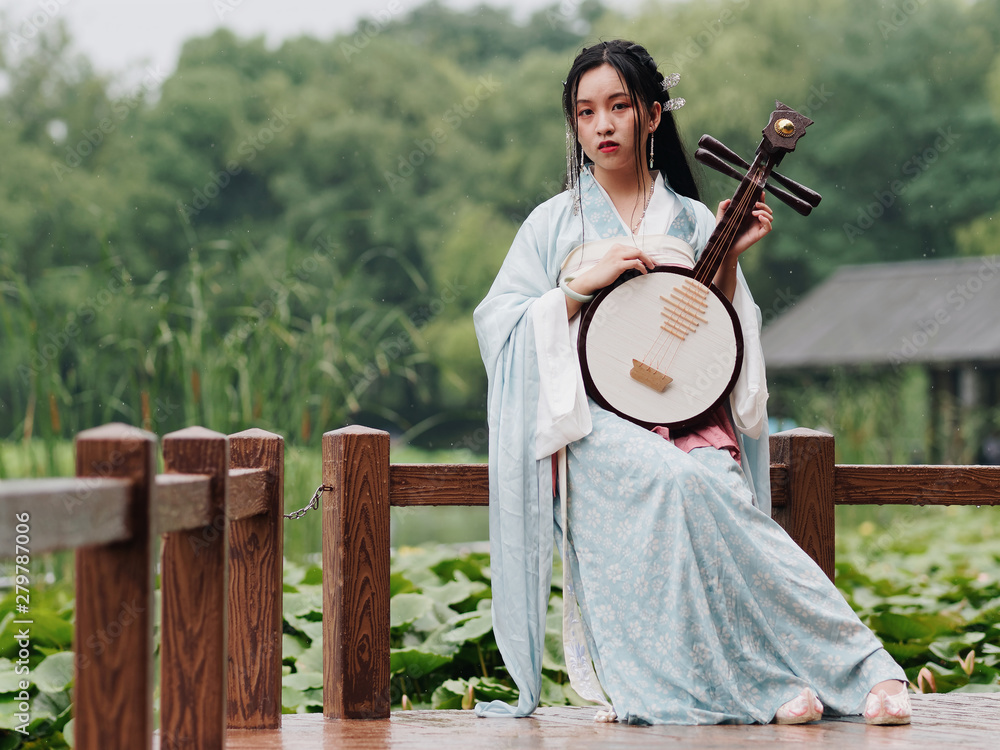 Beautiful Asian woman in cyan costume clothes hanfu holding yueqin ...